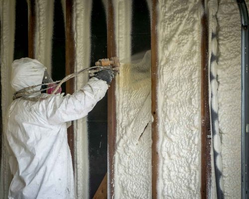 A man spraying in spray foam insulation