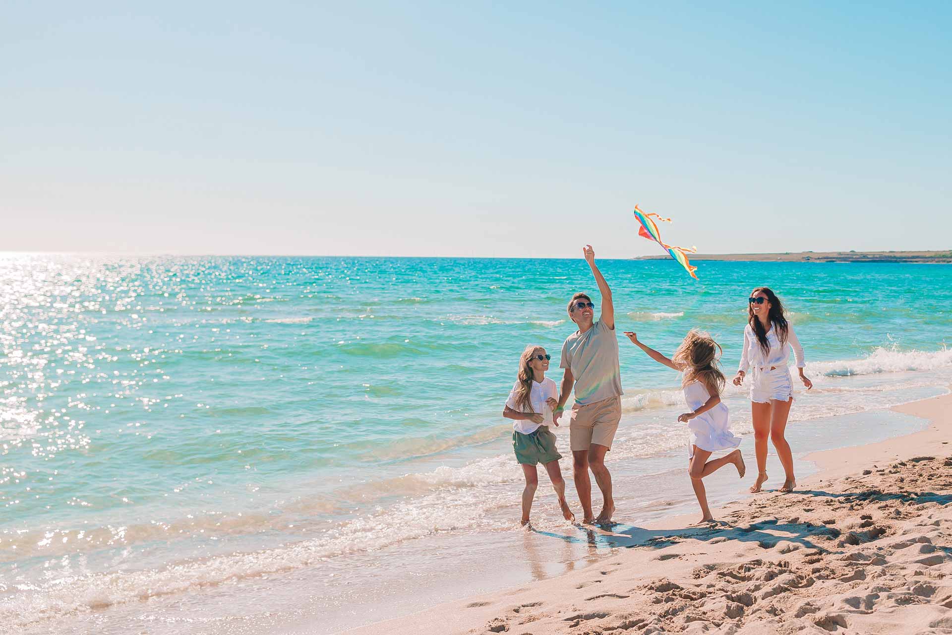 Family flying a kite on a beach